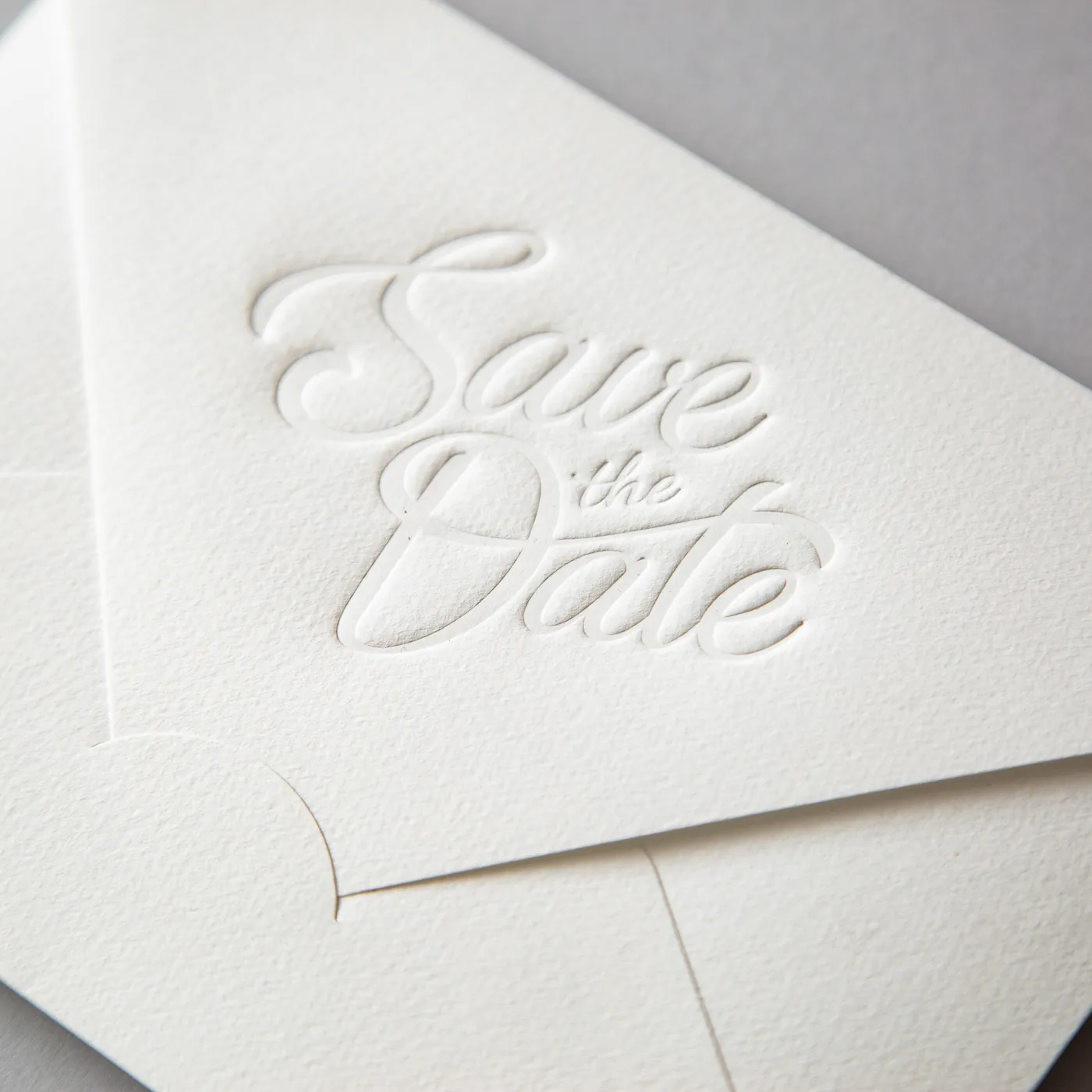 Bijela kuverta sa slijepim tiskom natpisa Save the Date